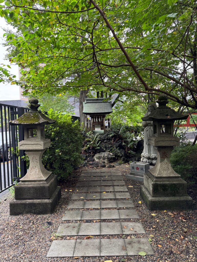 石灯籠と小さな祠が並ぶ境内の小道