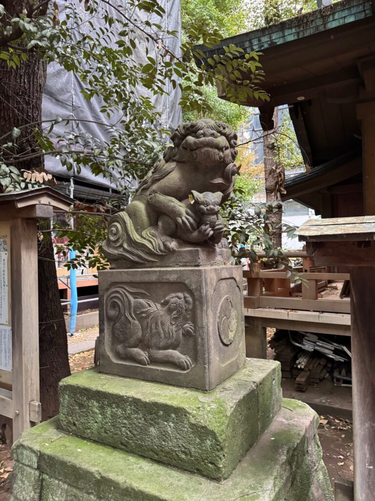 稲荷鬼王神社の社殿前で本殿を護る力強い造形の子連れ狛犬像