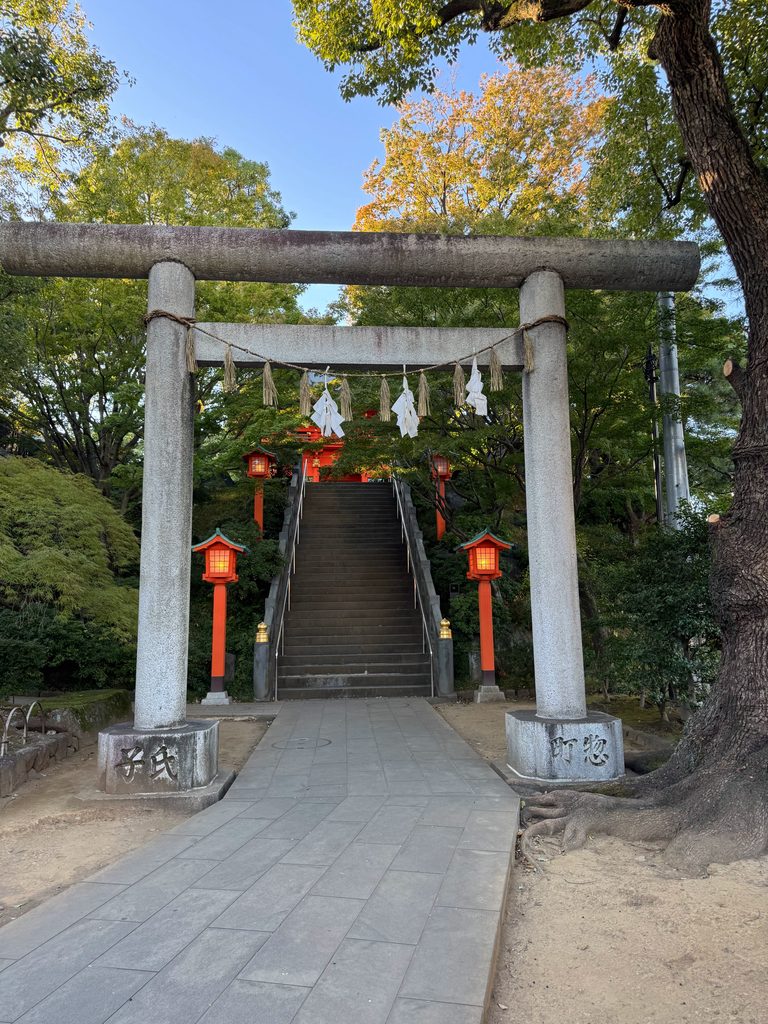 穴八幡宮の正面参道入口にある大きな石鳥居と朱塗りの灯籠