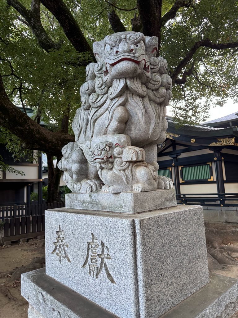 穴八幡宮拝殿前にある足元に子供を連れた大きな「奉献」の狛犬
